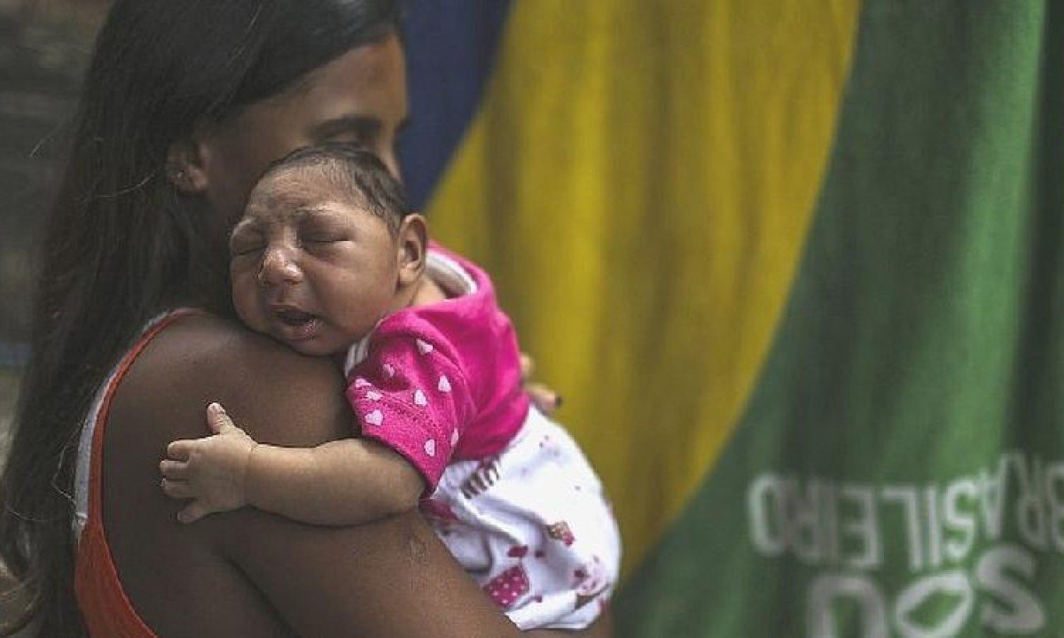 Mãe segura bebê com microcefalia -  (crédito: EPA)