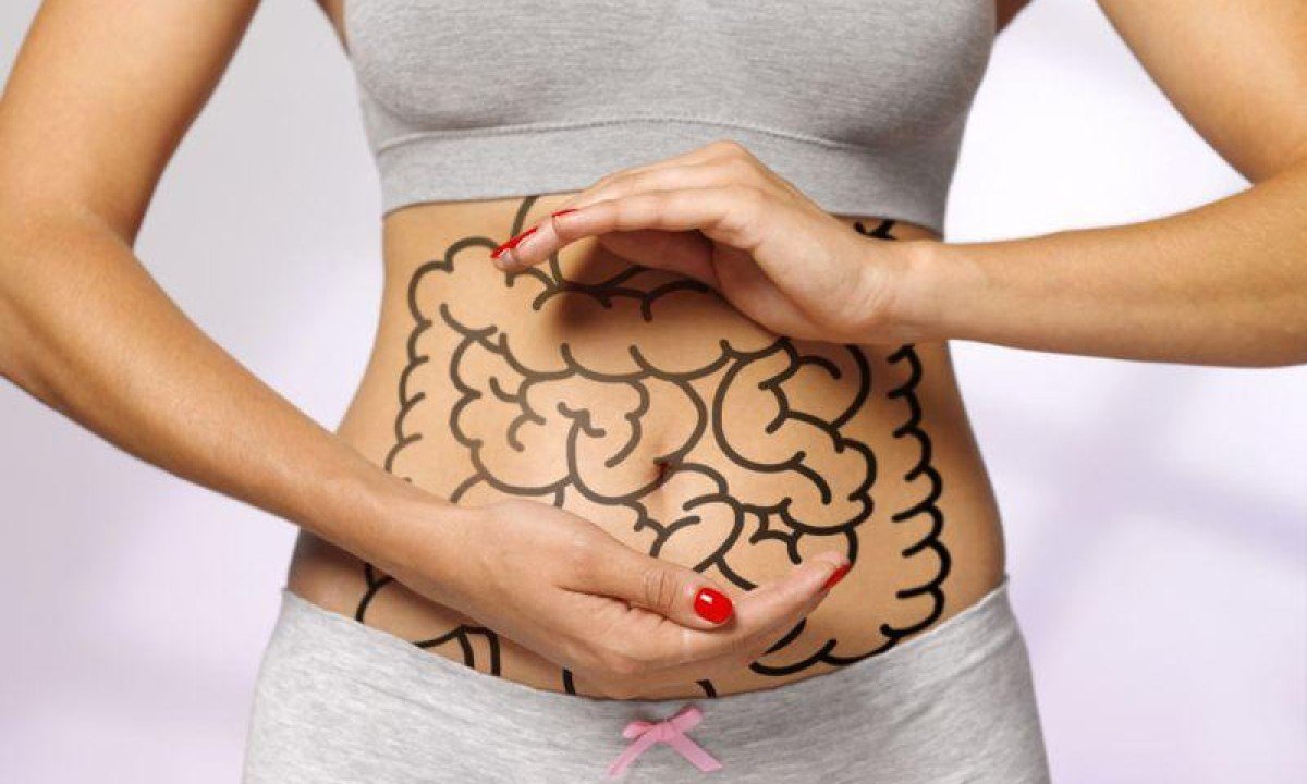 mulher mostra a barriga com intestino desenhado nela -  (crédito: Getty Images)