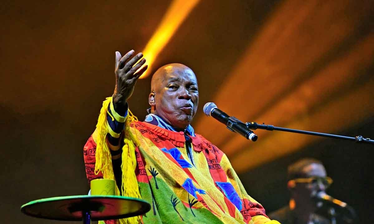 Vestindo manto multicolorido, Milton Nascimento está sentado em frente ao microfone e gesticula para o público durante show em BH -  (crédito: Alexandre Guzanshe/EM/D.A Press - 13/11/2022)