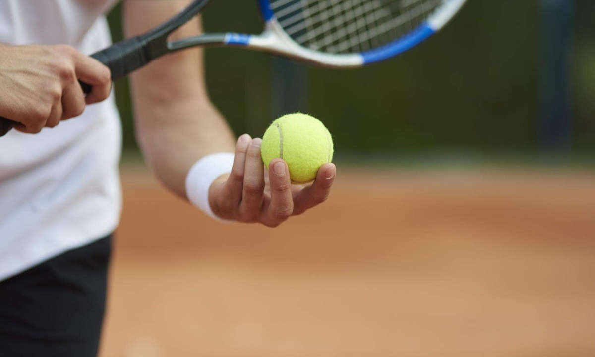 Mão de atleta segurando bola de tênis e raquete prestes a jogar -  (crédito: Freepik)