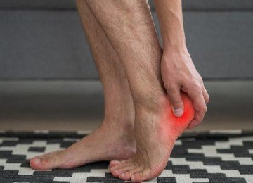Homem segura calcanhar que está vermelho, sinalizando fascite plantar -  (crédito: Getty Images)