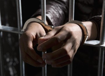 Mãos de pessoa algemada atrás das grades -  (crédito: Getty Images)