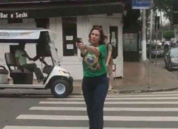 Zambelli apontando arma, opositor fora de cena, no meio de rua. -  (crédito: Redes Sociais/Reprodução)