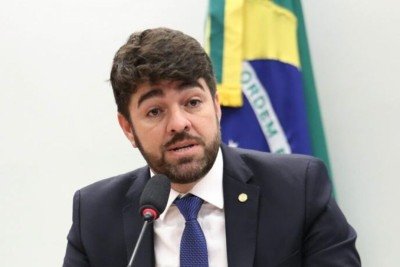 Deputado Federal Zé Vitor (PL-MG) fala ao microfone com uma bandeira do Brasil ao fundo -  (crédito: Billy Boss/Câmara dos Deputados)