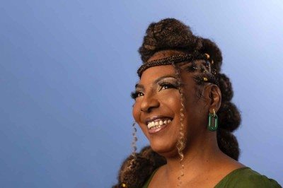 Maquiada e de perfil, a atriz Rejane Faria sorri - 