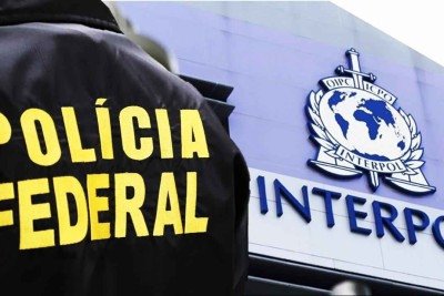 Polícia Federal de costas com símbolo da interpol ao fundo -  (crédito: Reprodução/Policia Federal)