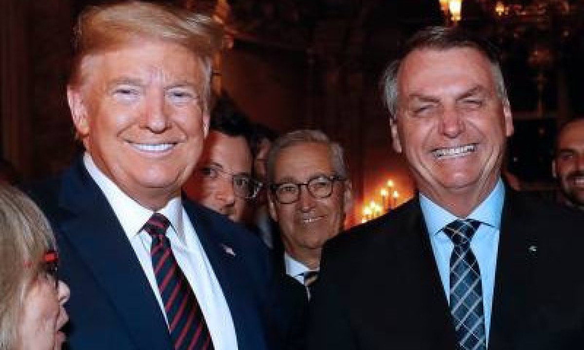 (FILES) In this handout file photo taken on March 07, 2020 and released by the Brazilian Presidency on March 12, 2020 US President Donald Trump (L), Brazilian President Jair Bolsonaro (R) and his press advisor Fabio Wajngarten (2-L, behind Trump), are seen during a dinner at Mar a Lago, in Palm Beach, Florida, United States. Jair Bolsonaro made the 