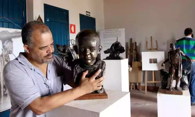 O artista Luciomar com uma das esculturas que homenageiam o filho perdido há 20 anos: 