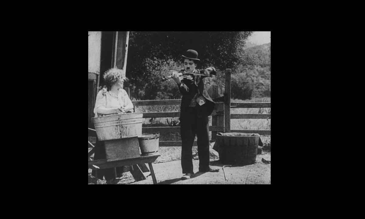 Charlie Chaplin toca violino em cena de O vagabundo, filme de 1916 -  (crédito: Reprodução)