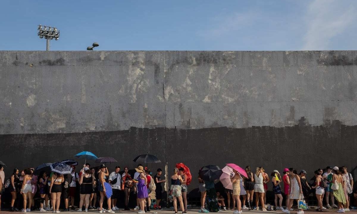  Fãs de Taylor Swift se abrigam do sol forte antes do show no Rio de Janeiro -  (crédito:  Eduardo Anizelli/Folhapress)