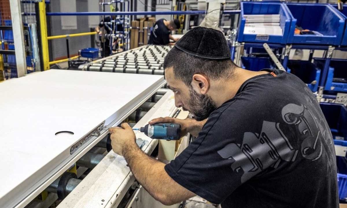 Operário de fábrica de portas de segurança em Israel prende parafuso; guerra afeta negócios no país - (crédito: Economia israelense sofre os efeitos do conflito com o Hamas) Operário de fábrica de portas de segurança em Israel prende parafuso; guerra afeta negócios no país - (crédito: Economia israelense sofre os efeitos do conflito com o Hamas)