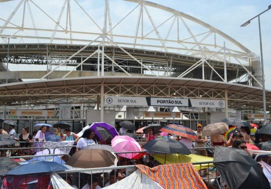  Público aglomerado do lado de fora do Estádio Nilton Santos, no RJ, usando guarda-chuvas contra o sol forte -  (crédito:  Paulo Carneiro/Ato Press/Folhapress)