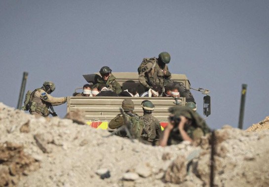  Soldados de Israel conduzem palestinos vendados em veículo militar -  (crédito: MAHMUD HAMS / AFP)