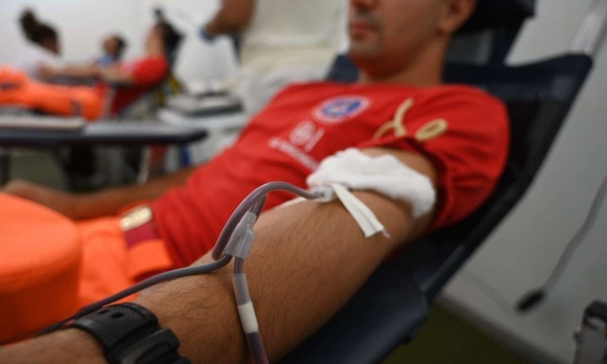 Bombeiro sentado em uma cadeira enquanto realiza doação de sangue -  (crédito: Leandro Couri /EM/DA. Press. Brasil. Belo Horizonte - MG)