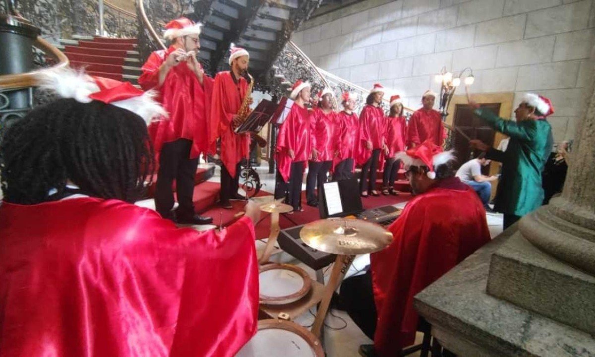 Coral de Natal canta na escadaria do Palácio da Liberdade. Todos utilizam capas vermelhas e, em frente ao coral, há um homem com terno verde fazendo comandando os cantores.  -  (crédito: Jair Amaral//EM/D.A.Press)