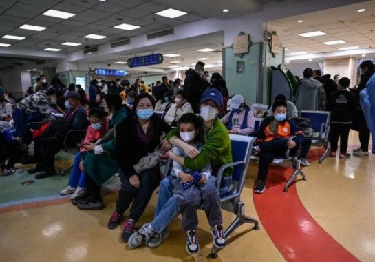 Crianças e adultos esperam em uma área de atendimento ambulatorial num hospital de Pequim por causa de problemas nas vias aéreas  -  (crédito: AFP)