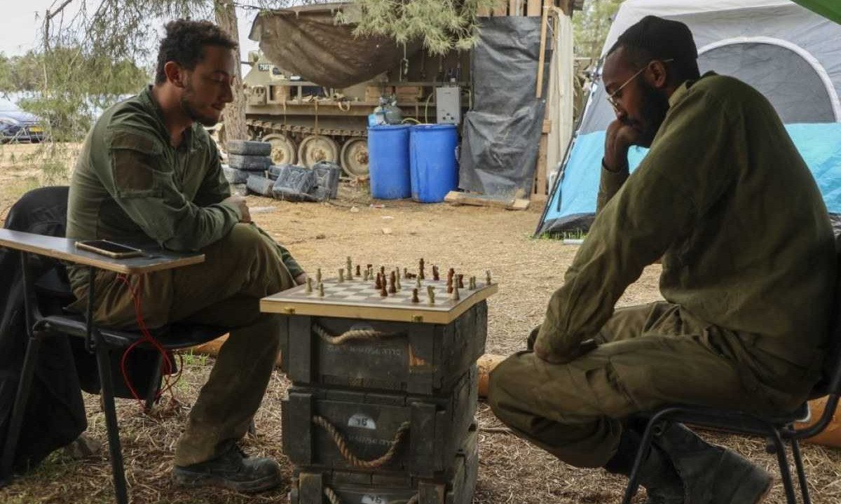  Soldados de Israel jogam xadrez durante a trégua da guerra contra o Hamas -  (crédito: GIL COHEN-MAGEN / AFP)