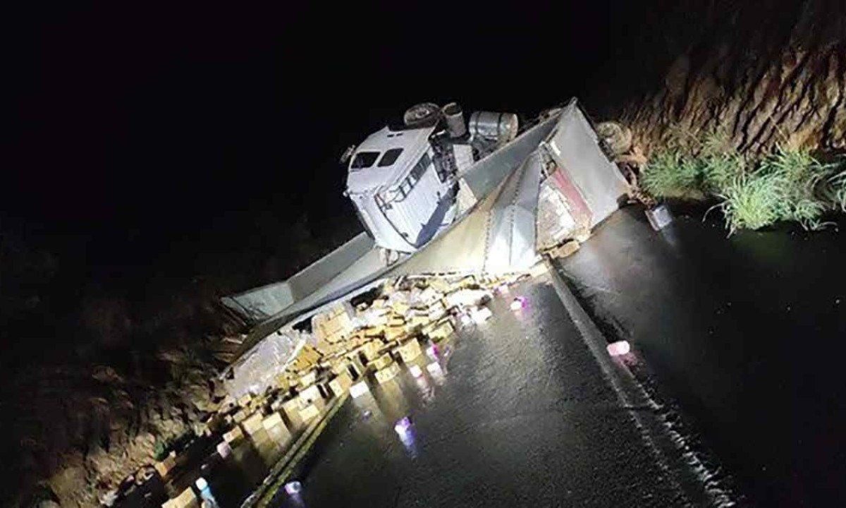 Carreta carregada de creme capilar tombou e interditou a BR-356, em Jequitaí, no Norte de Minas, deixando asfalto escorregadio -  (crédito: Sala de Imprensa/CBMMG)