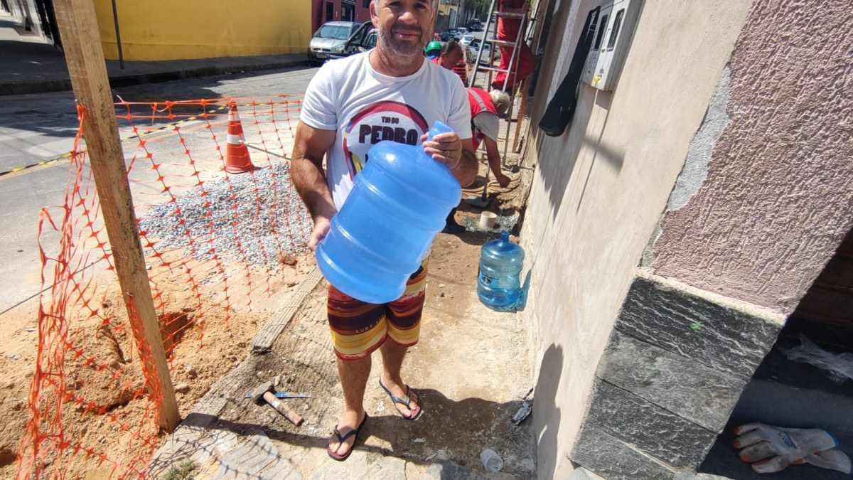 homem segurando um galão de água 