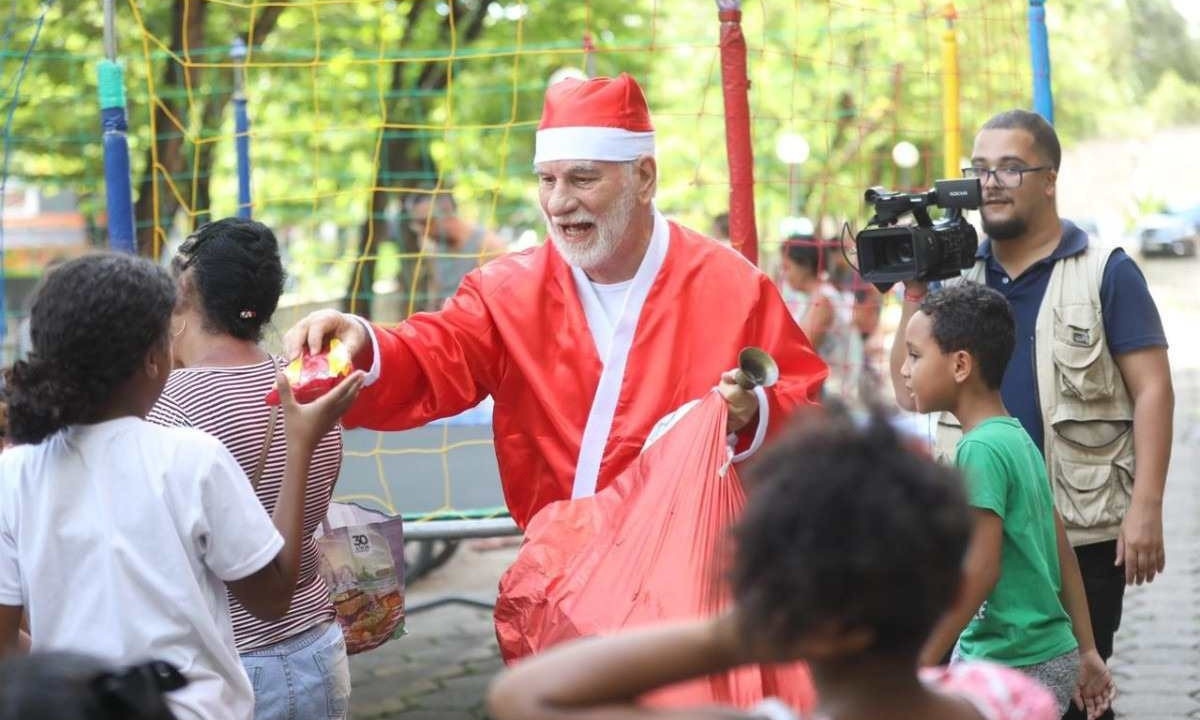 O padre Carlos Geraldo Pinto de Oliveira, de 80 anos, vestiu a roupa de Papai Noel e abraçou a garotada -  (crédito: NATHÁLIA FARNETTI/ARQUIDIOCESE DE BH/DIVULGAÇÃO)