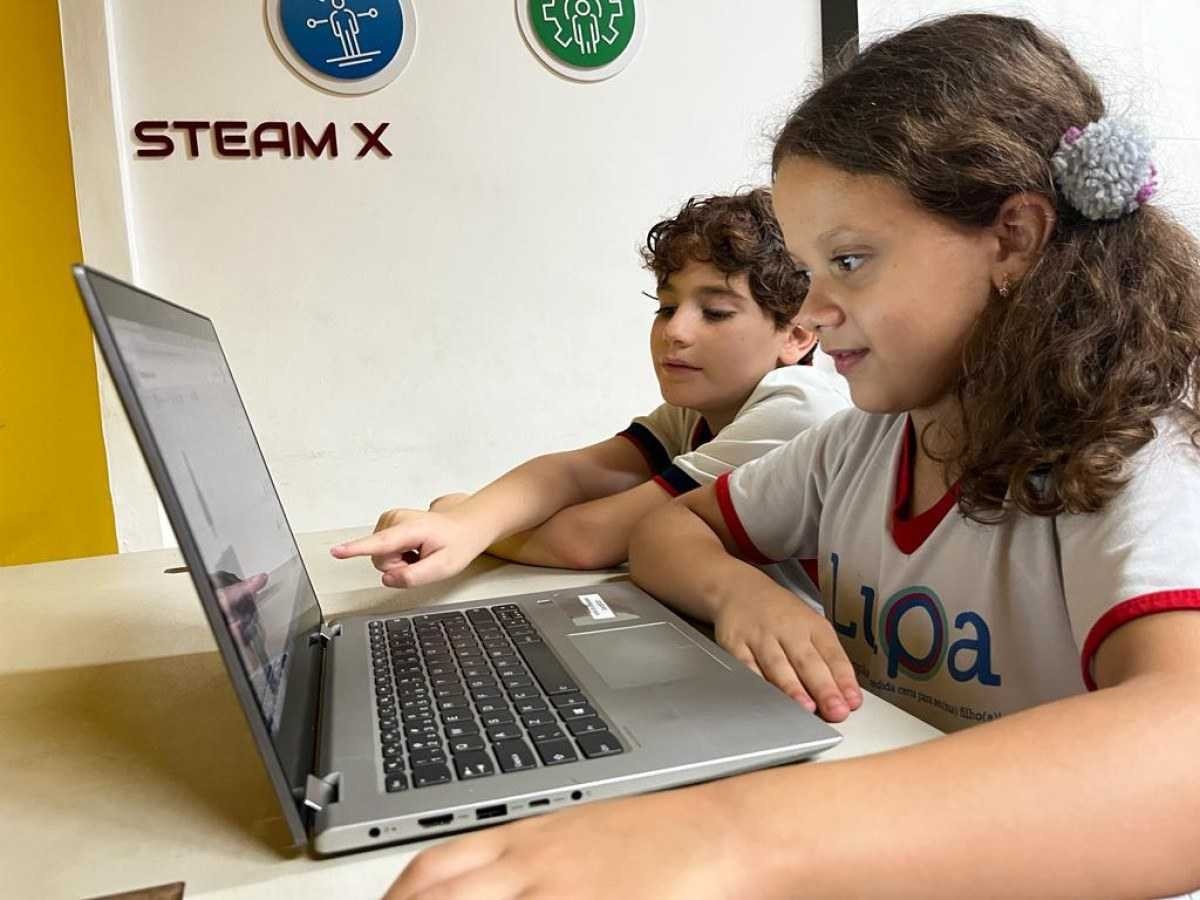 Dois estudantes do Programa Lupa mexendo no computador juntos