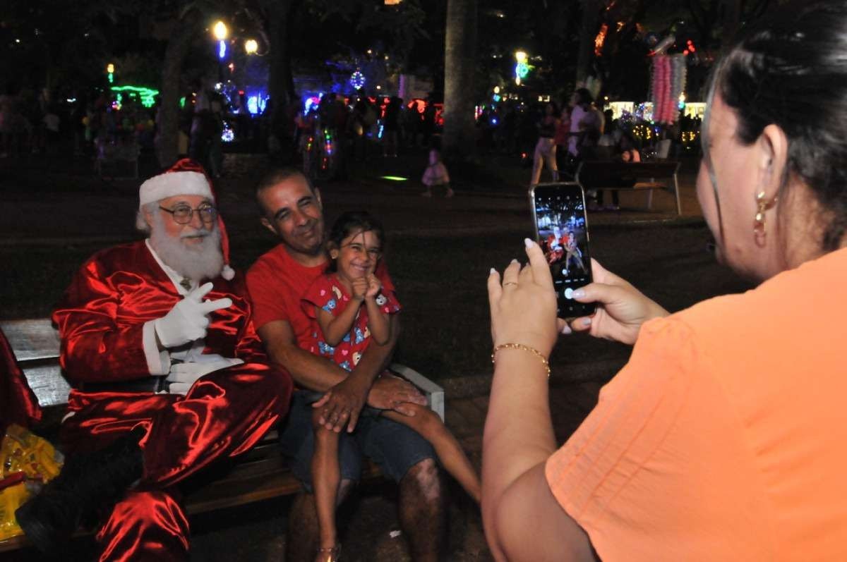 O Papai Noel Francisco de Assis pede R$ 10 por foto tirada em um banco do cartão-postal