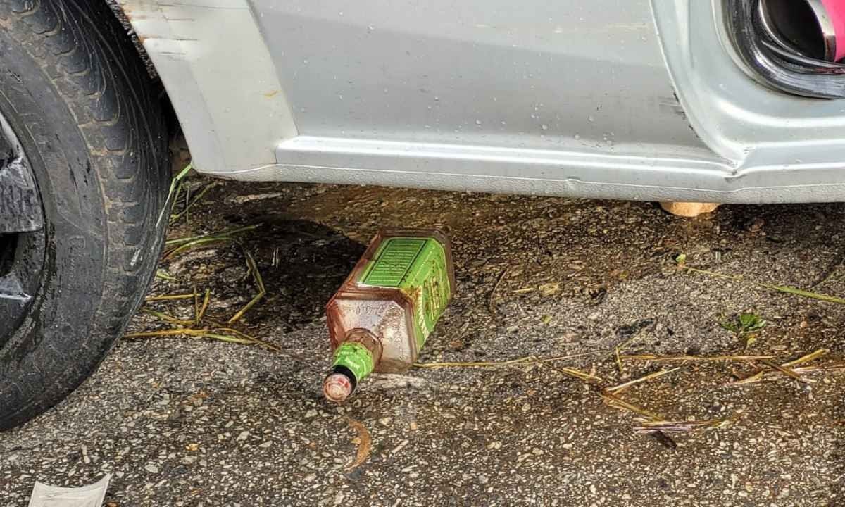 Garrafa de bebida alcoólica estava perto do carro