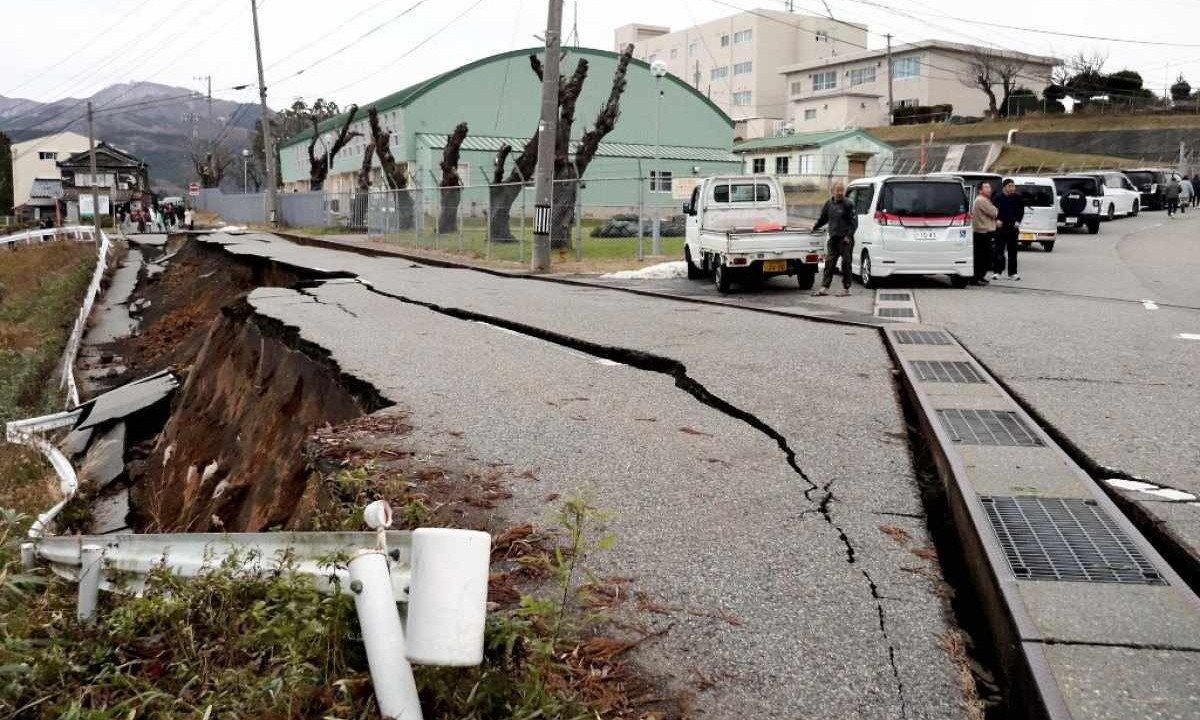Pessoas próximas a cratera aberta por terremoto em Wajima, que atingiu 7.5 graus na escala Richter -  (crédito:  Yomiuri Shimbun/AFP)