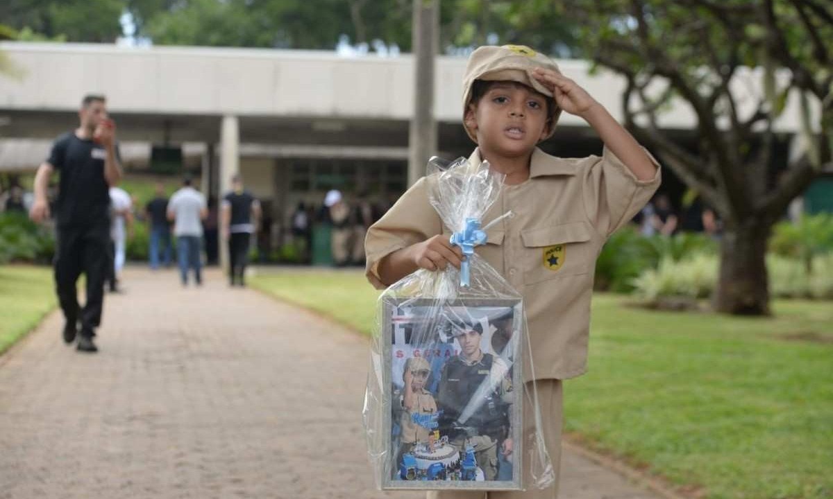 Juan Lucas, de 5 anos, foi ao enterro levando uma foto com o sargento Roger Dias da Cunha, morto em perseguição a fugitivo em BH -  (crédito: Túlio Santos/EM/D.A.Press)