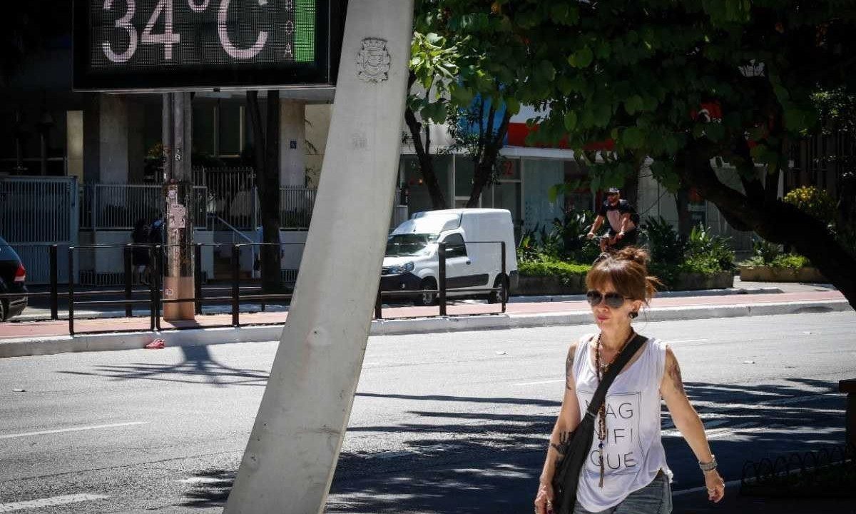 Mulher de short e camiseta passa próximo a termômetro de rua  marcando alta temperatura em São Paulo -  (crédito: Aloisio Mauricio /Fotoarena/Folhapress)