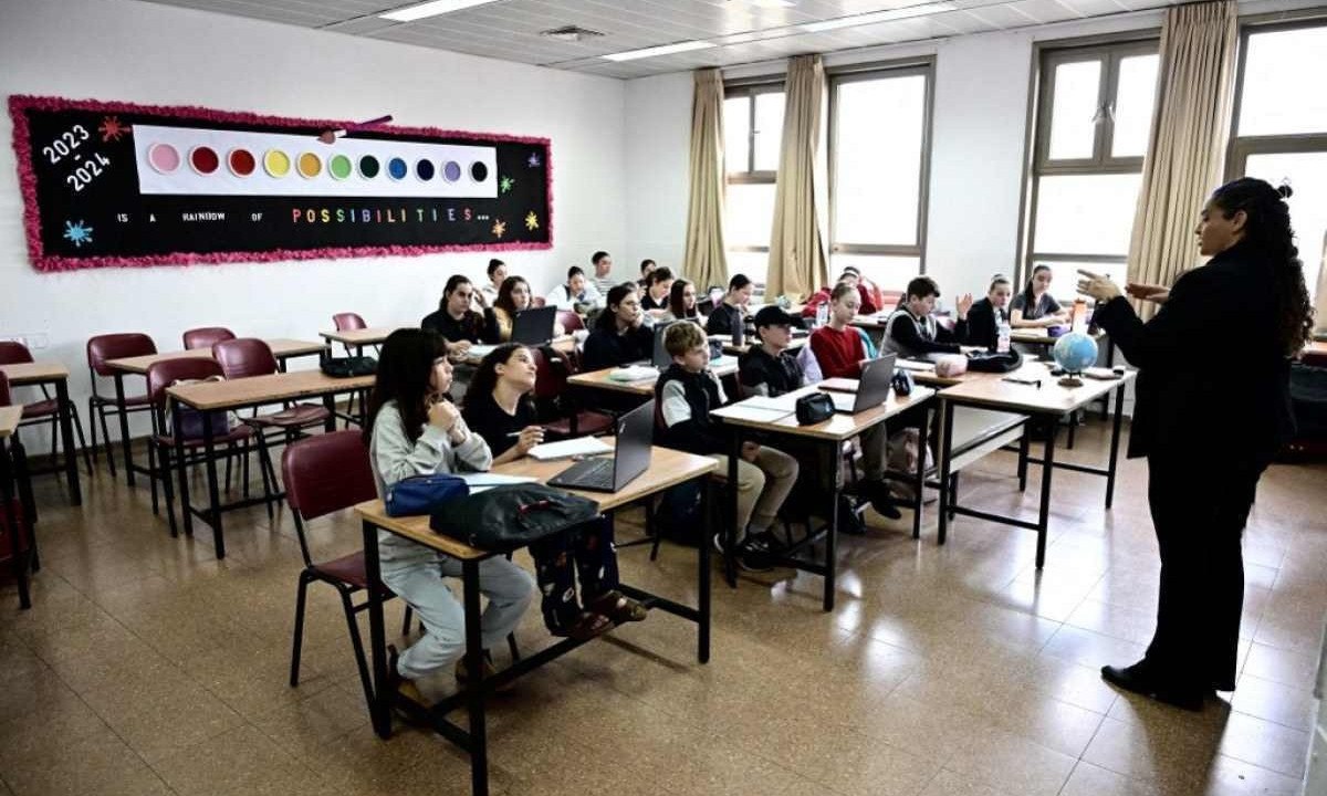 Diretora da escola israelenseensina alunos sobre como usar abrigo antimísseis na Escola Secundária da Academia de Jerusalém de Música e Dança, um exercício matinal que se tornou um ritual desde o início da guerra em Gaza - (crédito: AFP)