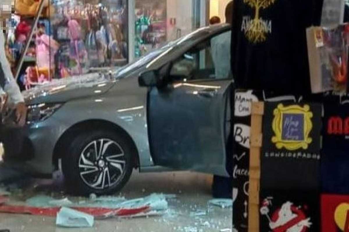 Mulher bate carro de exposição em loja de shopping
