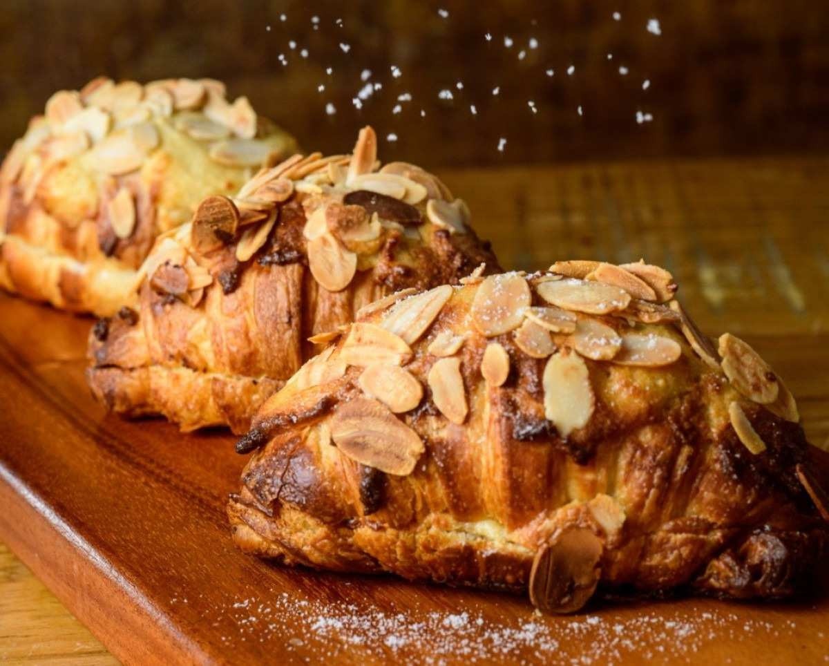Depois de assados, os croissants de amêndoas são recheados com frangipane, um saboroso creme de amêndoas, e cobertos com amêndoas fatiadas