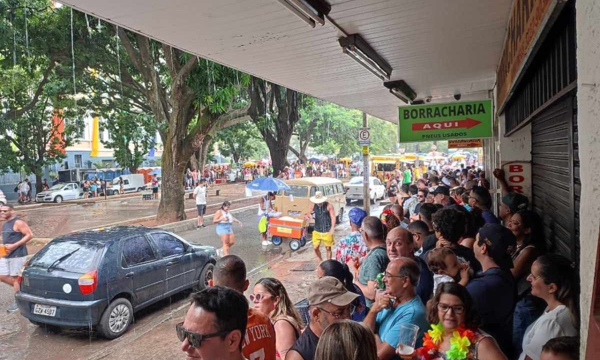 Foliões se protegendo de chuva em baixo de marquise -  (crédito: Alexandre Guzanshe/EM/D.A.Press)