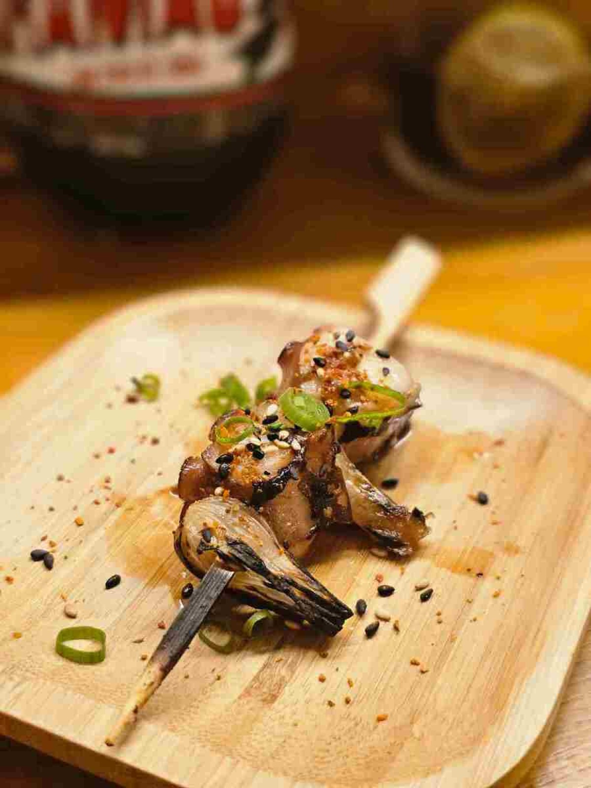 Grelhado na churrasqueira japonesa, o polvo ganha sabor em um espetinho com conserva de cebolinha japonesa e o tempero togarashi