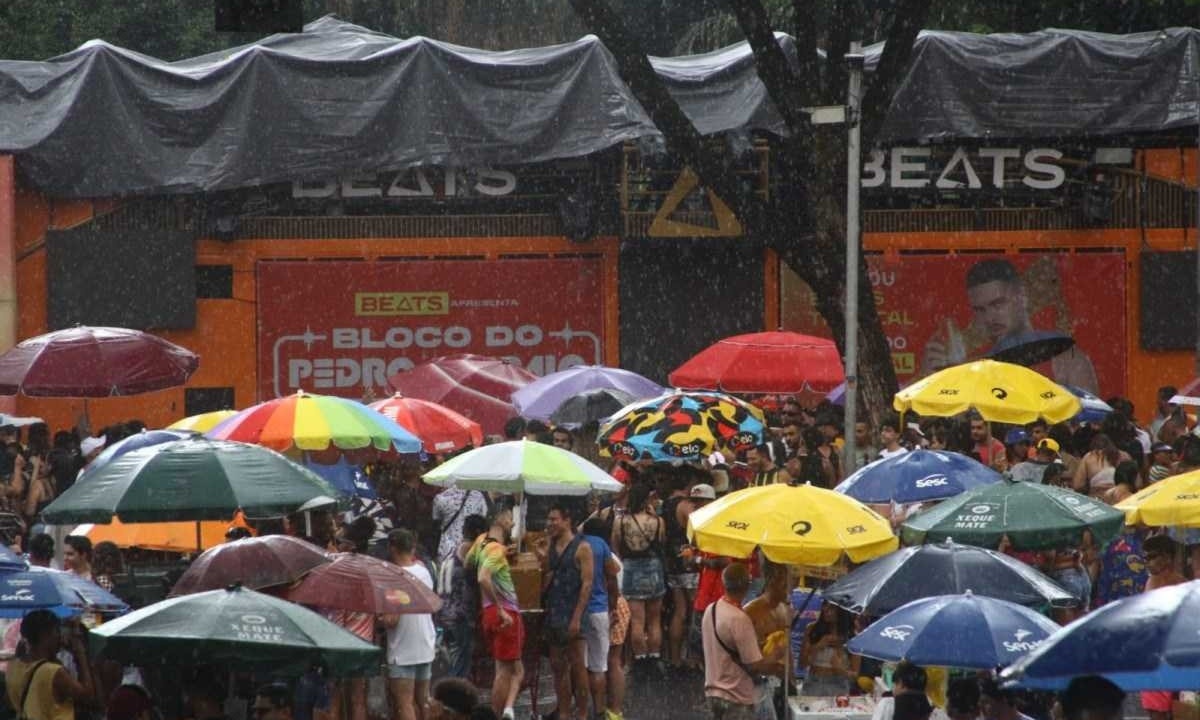Foliões se escondem da chuva durante bloco de carnaval na Avenida Afonso Pena -  (crédito: Marcos Vieira/EM/D.A. Press)