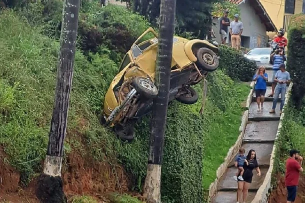 Fusca ficou preso no alto de barranco depois de motorista perder o controle da direção às margens de BR no Sul de Minas -  (crédito: Redes Sociais/Reprodução)