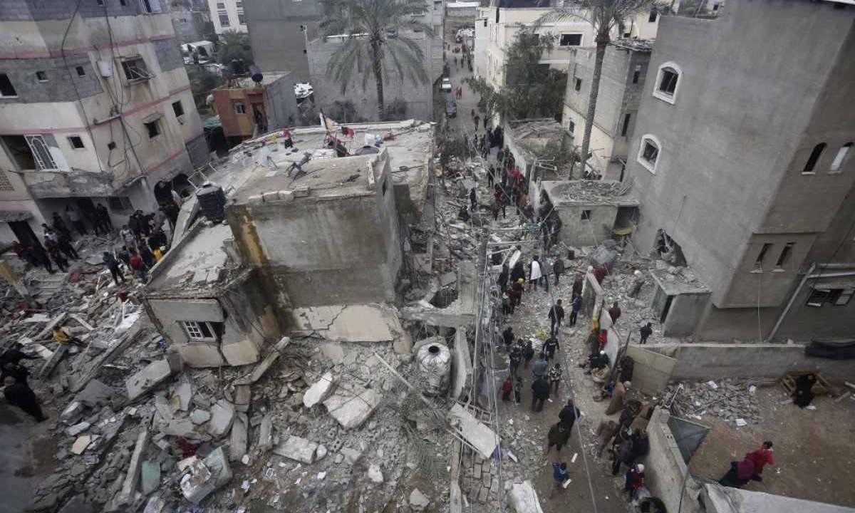 Pessoas procuram vítimas nos escombros da casa da família Baraka em Deir al-Balah, no centro da Faixa de Gaza, depois de ter sido atingida por um ataque aéreo israelense -  (crédito:  AFP)