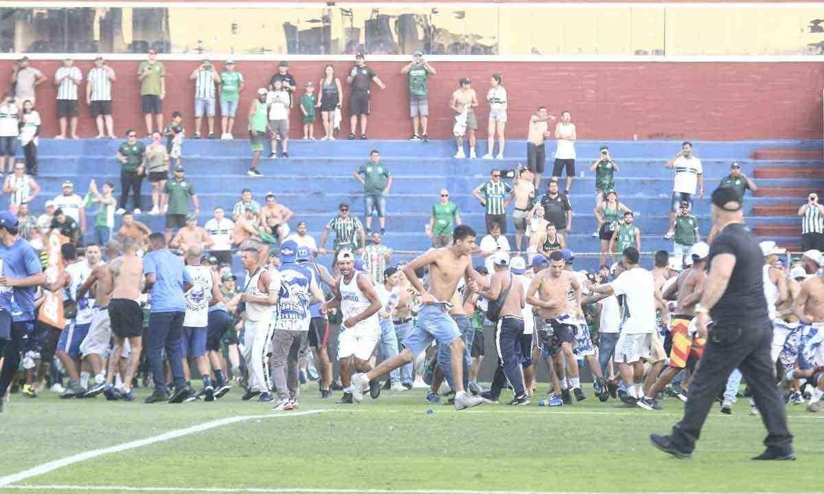 Torcedores de Coritiba e Cruzeiro brigam no gramado do estádio Couto Pereira, pelo Campeonato Brasileiro de 2023 -  (crédito: Agif/Folhapress – 11/11/23)