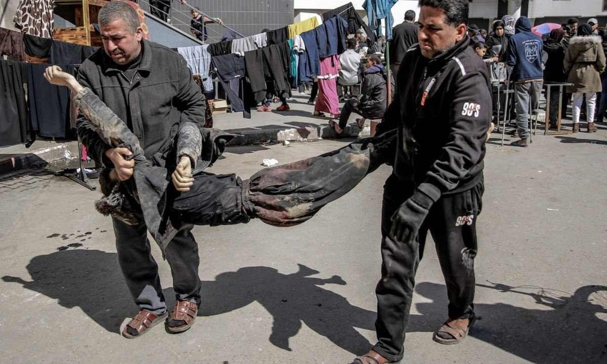 Palestinos carregam corpos de vítimas de incidente no Norte de Gaza, em que 112 pessoas foram mortas -  (crédito: AFP)