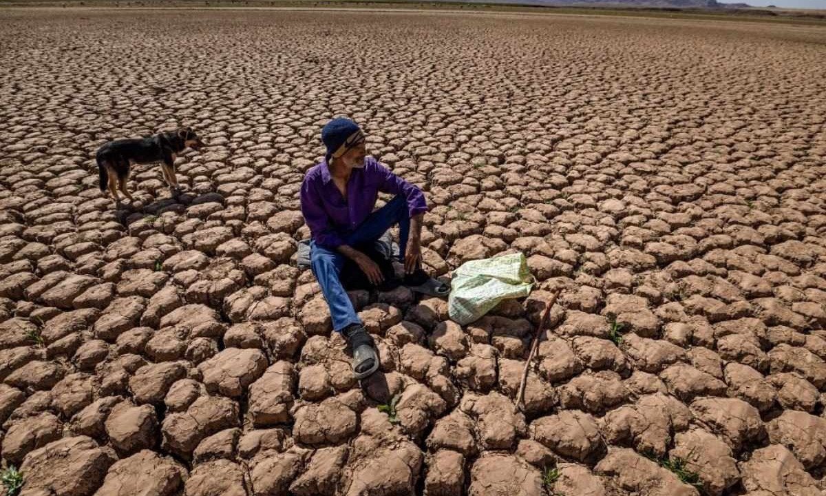 Um pastor cuida de seu rebanho de ovelhas sentado em terra rachada na barragem de al-Massira, cerca de 140 quilômetros ao sul de Casablanca -  (crédito: Fadel SENNA / AFP)