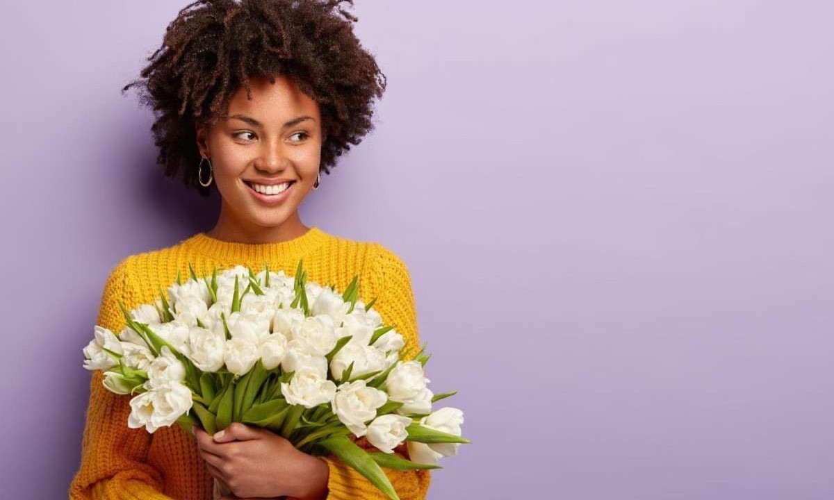 Mulher segurando flores simboliza celebração do Dia da Mulher em relação às diversas conquistas pela igualdade e avanços sociais -  (crédito: Freepik)
