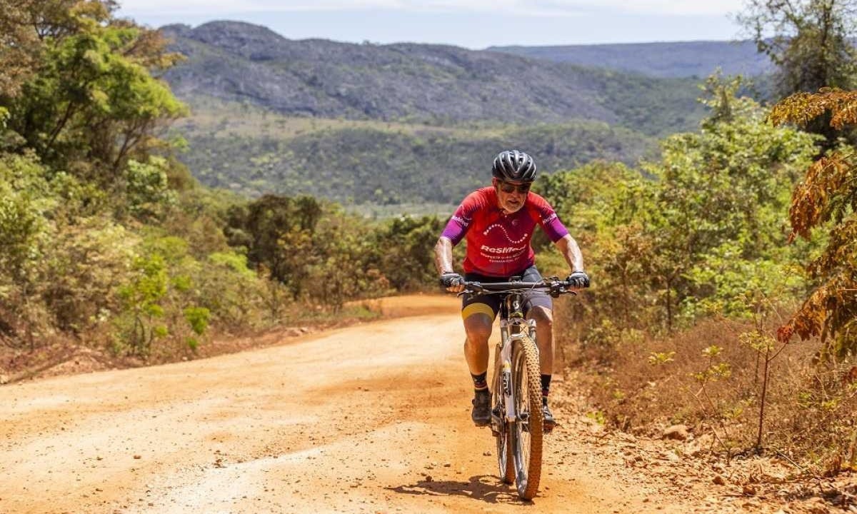 Aluizio, de 64 anos, pedalando em uma estrada 