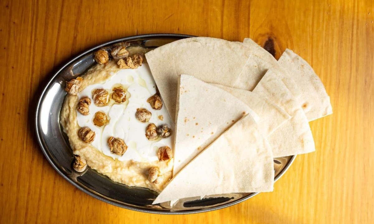 Porção de Hummus com coalhada e pipoca de grão de bico, acompanha pão pita