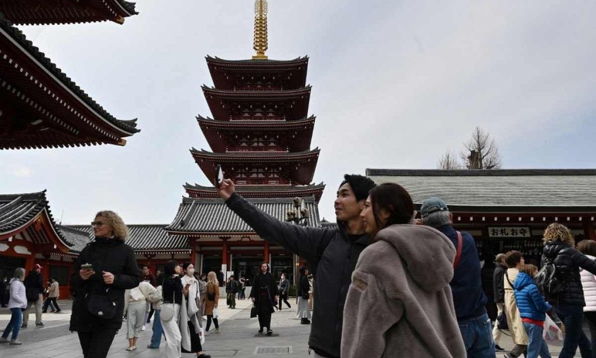Visitantes fazem selfie no templo Sensoji, em Tóquio
       -  (crédito: Kazuhiro NOGI / AFP)