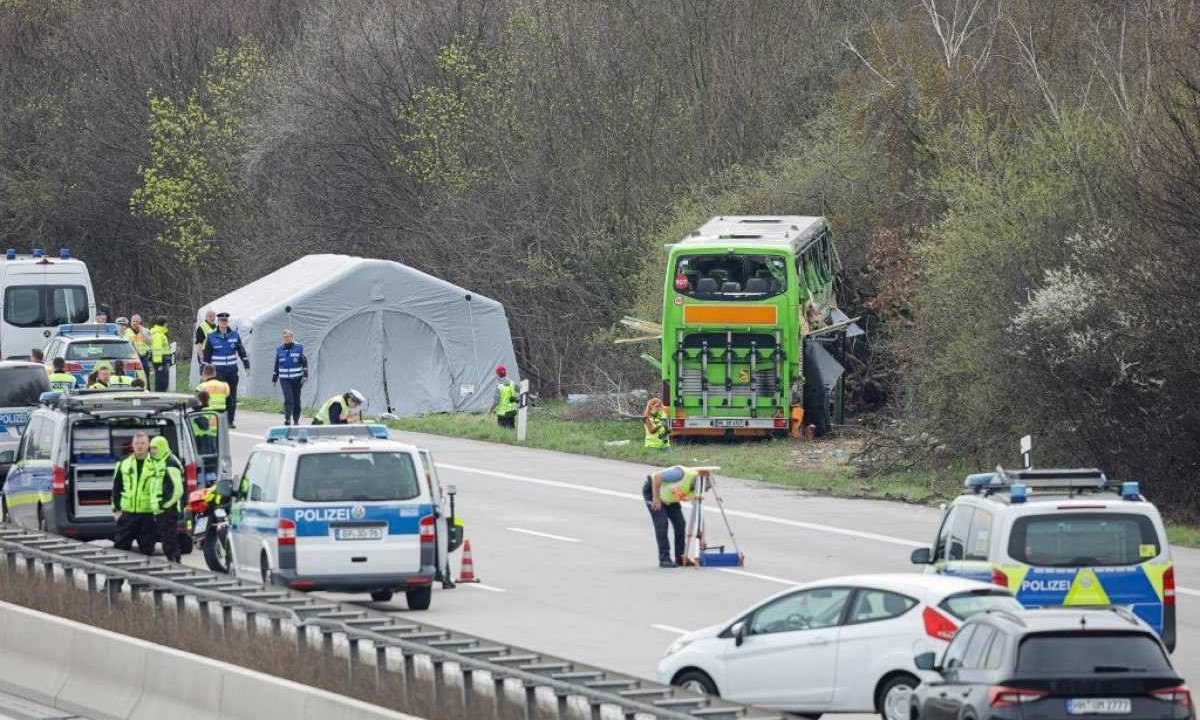  Policiais no local do acidente de ônibus na rodovia A9, onde pelo menos cinco pessoas morreram -  (crédito: Jens Schlueter / AFP)