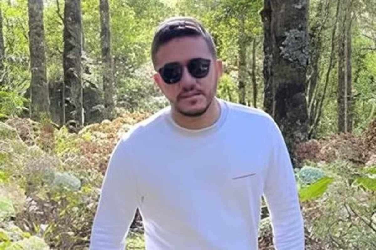 Fernando Sastre de Andrade Filho, de 25 anos, veste camisa branca e usa óculos escuros ao posar para foto em região rodeada por árvores 