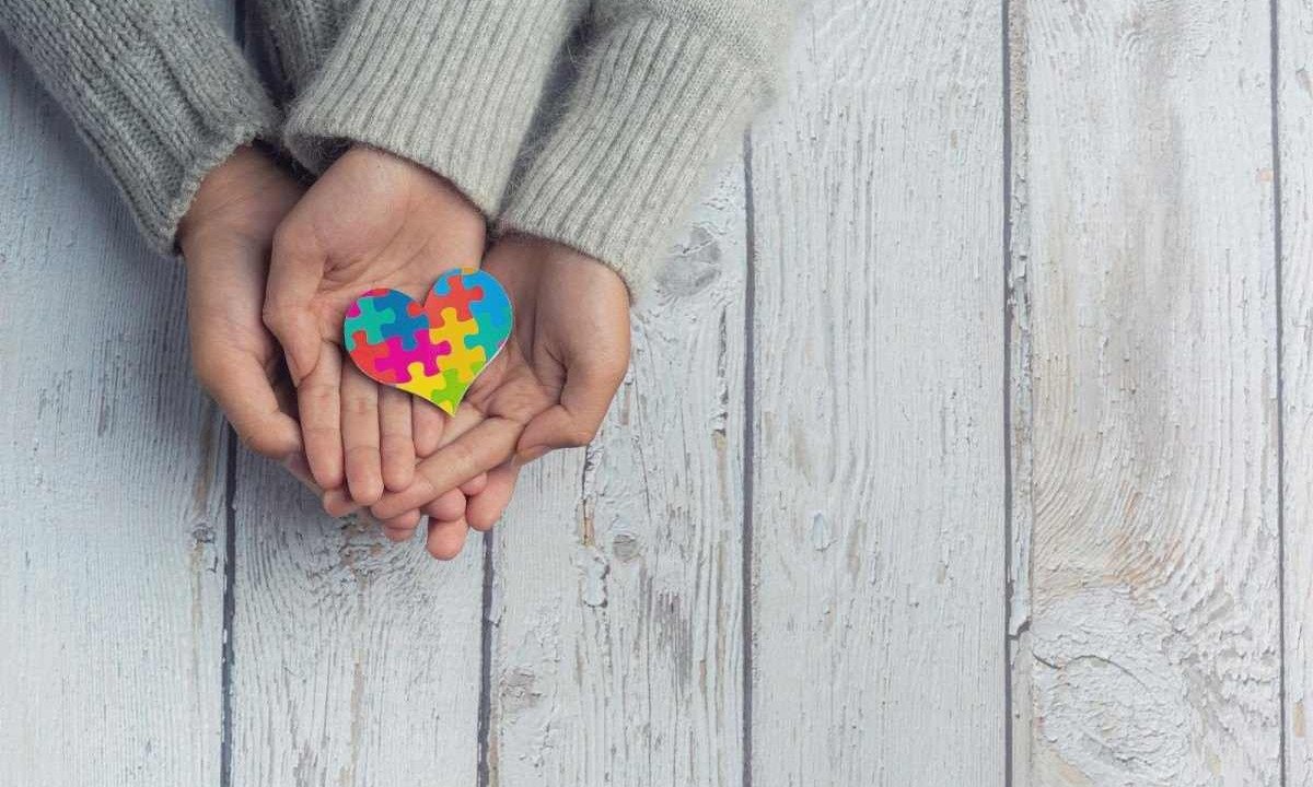 Três mãos seguram um coração, montado com peças de quebra-cabeça coloridas, alertando sobre o crescimento no número de diagnósticos entre adultos, quando o ideal, seria entre dois e três anos de idade  -  (crédito: Freepik)