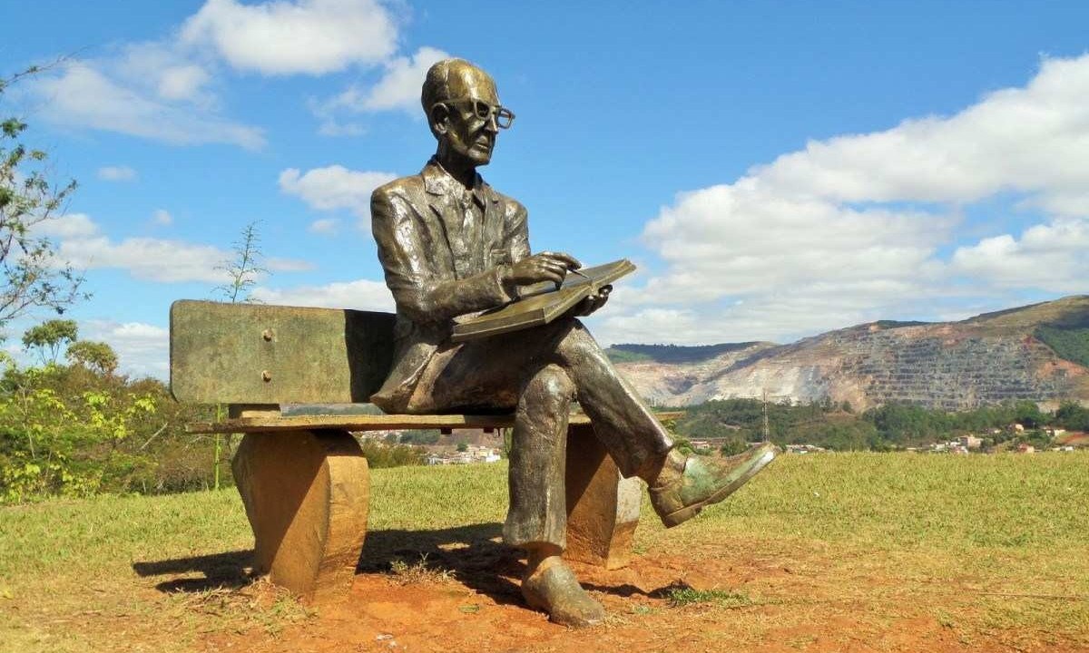 No Memorial Carlos Drummond de Andrade, a estátua do poeta descansa e, ao fundo em contraste, o Pico do Cauê, desgastado por anos de mineração -  (crédito: Elaine Diniz/Divulgação )