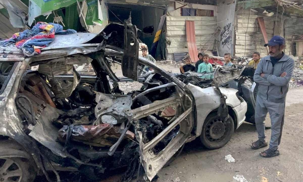  Onlookers check the car in which three sons of Hamas leader Ismail Haniyeh were reportedly killed in an Israeli air strike in al-Shati camp, west of Gaza City on April 10, 2024, amid the ongoing conflict between Israel and the Palestinian Hamas militant group. Qatar-based Ismail Haniyeh said his three sons and "some of" his grandchildren had been killed in the strike in an interview with Al Jazeera. The strike came as talks in Cairo aimed at a ceasefire and a hostage release deal dragged on without signs of a breakthrough. Israel did not immediately comment on the strike. (Photo by AFP)
       -  (crédito:  AFP)